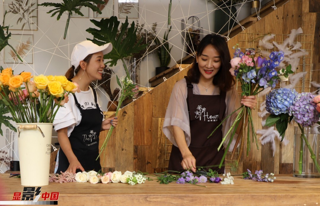 “昆明是鮮花的原產(chǎn)地，有亞洲最大的鮮切花交易市場，可以說具備開花店的天時地利；另外和很多女孩一樣，我從小也就有開花店的夢想！”說起當(dāng)初的決定，王黎媛說一是因?yàn)閴粝耄硗庖哺ッ鬟@個城市產(chǎn)花、賣花的“基因”有關(guān)。圖為王黎媛和同事在制作花束。新華網(wǎng) 周亞平/攝 念新洪/文